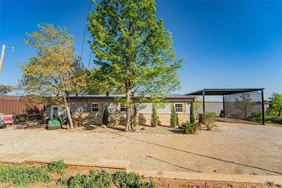 Back of house with stone siding and driveway Back of house with stone siding and driveway