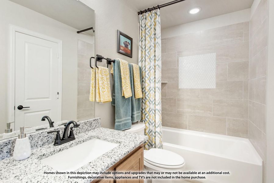 Bathroom with granite vanity, tub-shower combo with tile surround, and patterned shower curtain Bathroom with granite vanity, tub-shower combo with tile surround, and patterned shower curtain