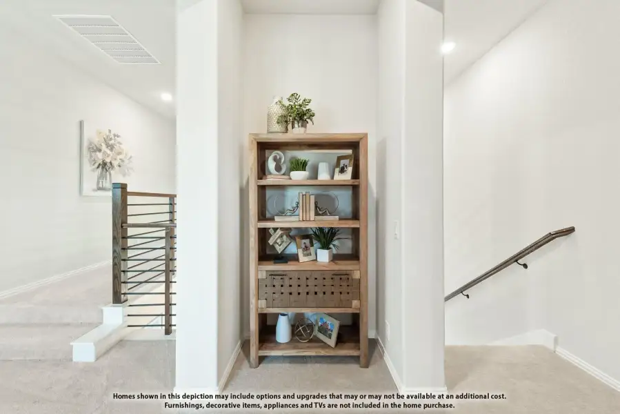 Upstairs hallway with wood bookshelf, decorative items, and staircase railing with metal balusters Upstairs hallway with wood bookshelf, decorative items, and staircase railing with metal balusters