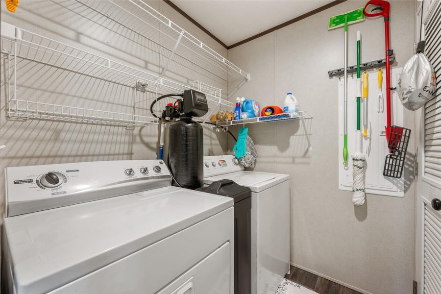 Laundry area featuring independent washer and dryer, crown molding, and wood finished floors