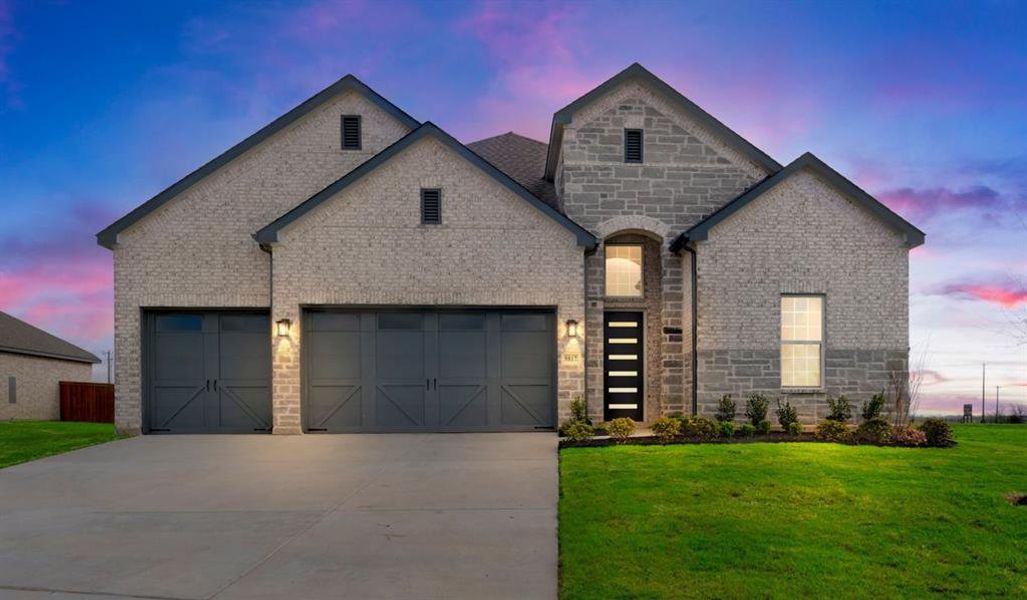 French provincial home featuring a garage and a lawn