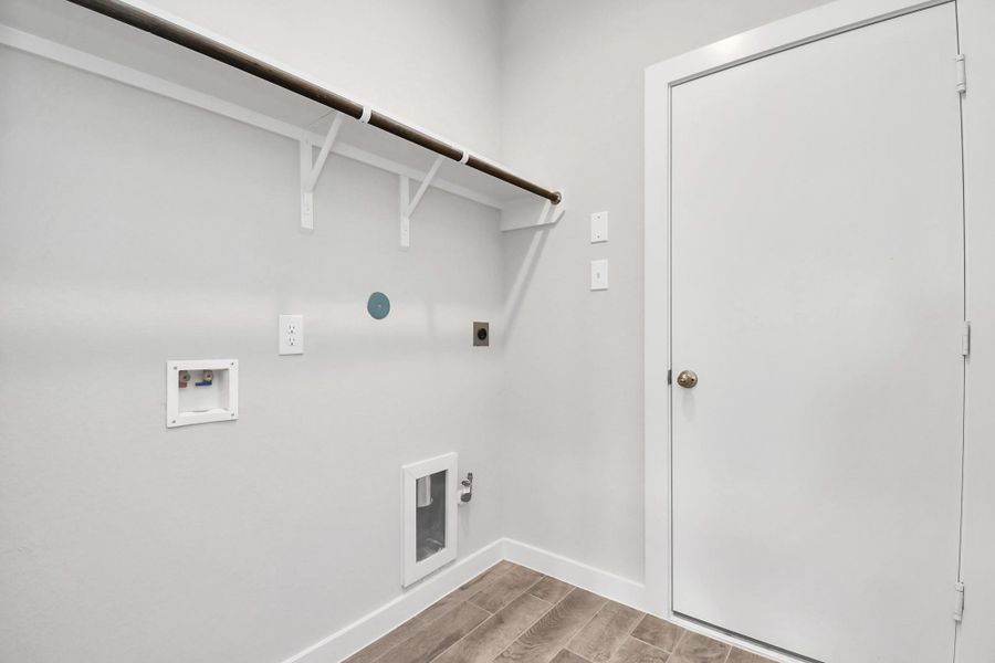 1st floor laundry room with both electric and gas dryer connections. Sample photo of completed home with similar floor plan. Actual colors and selections may vary.