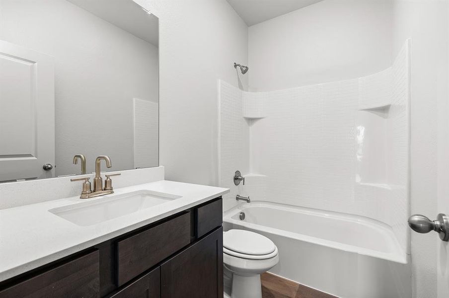 Full bath with toilet, vanity, shower / bathtub combination, and wood finished floors