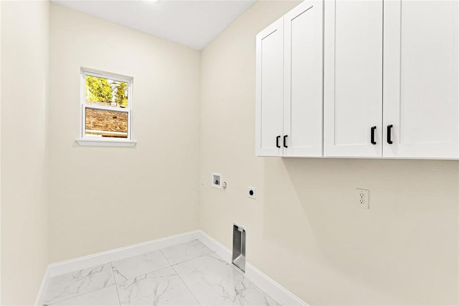 Laundry room with hookup for an electric dryer, cabinets, and hookup for a washing machine