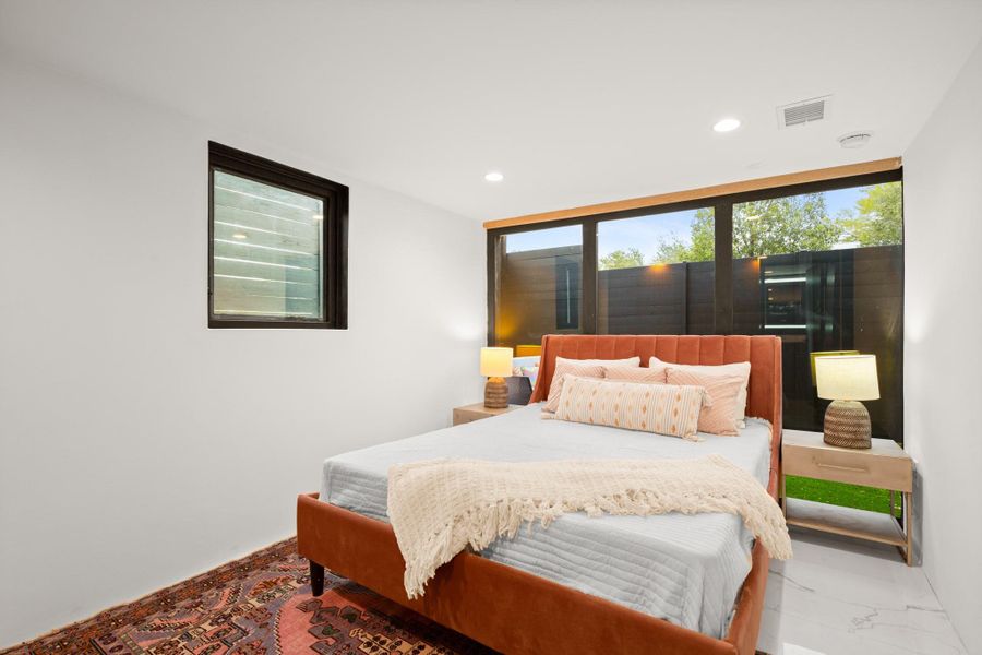 Bedroom with recessed lighting, multiple windows, and marble finish flooring