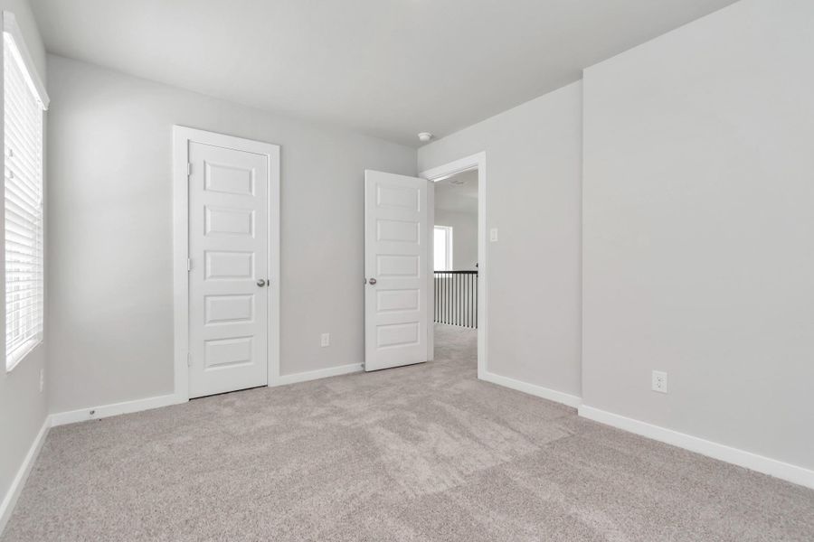 Generously sized secondary bedrooms featuring spacious closets, soft and inviting carpeting underfoot, large windows allowing plenty of natural light, and the added touch of privacy blinds for your personal retreat. Sample photo of completed home with similar floor plan. Actual colors and selections may vary.