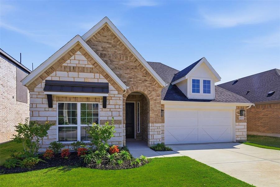 Exterior featuring a blend of light-toned stone and brick, a front-facing gable, and an arched entry