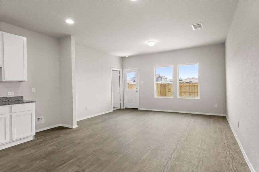 Unfurnished living room with recessed lighting and dark wood-style floors