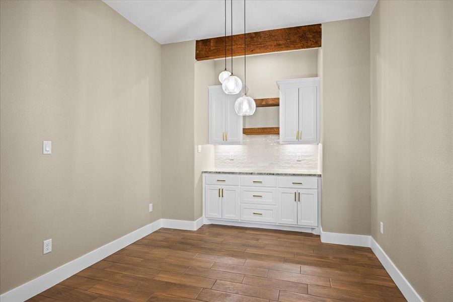 Unfurnished dining area featuring beamed ceiling and dark wood-type flooring Unfurnished dining area featuring beamed ceiling and dark wood-type flooring