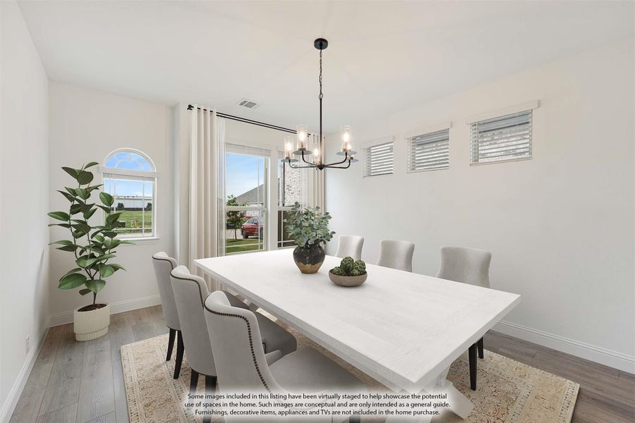 Dining room with white table, gray upholstered chairs, black chandelier, and hardwood floors