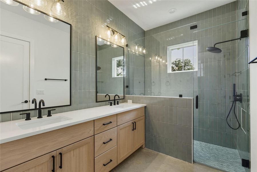 Bathroom with a shower stall, double vanity, and tile walls Bathroom with a shower stall, double vanity, and tile walls