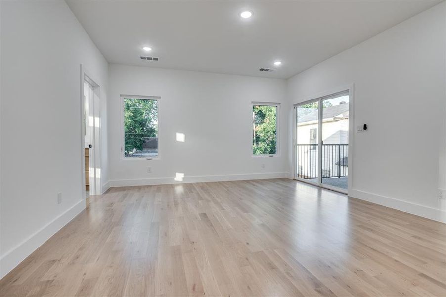 Empty room featuring healthy amount of natural light, light wood-style floors, and recessed lighting Empty room featuring healthy amount of natural light, light wood-style floors, and recessed lighting