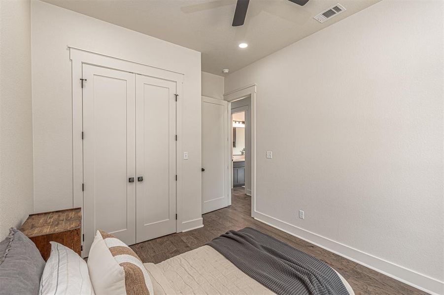 Bedroom with a closet, ceiling fan, dark wood-style floors, and recessed lighting