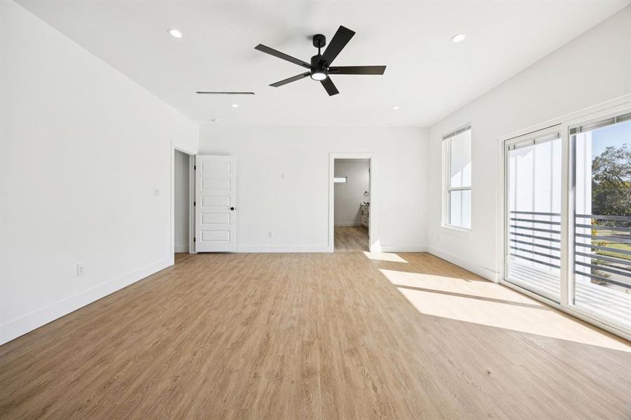 Unfurnished bedroom with light wood-style floors, ensuite bath, recessed lighting, a ceiling fan, and access to outside