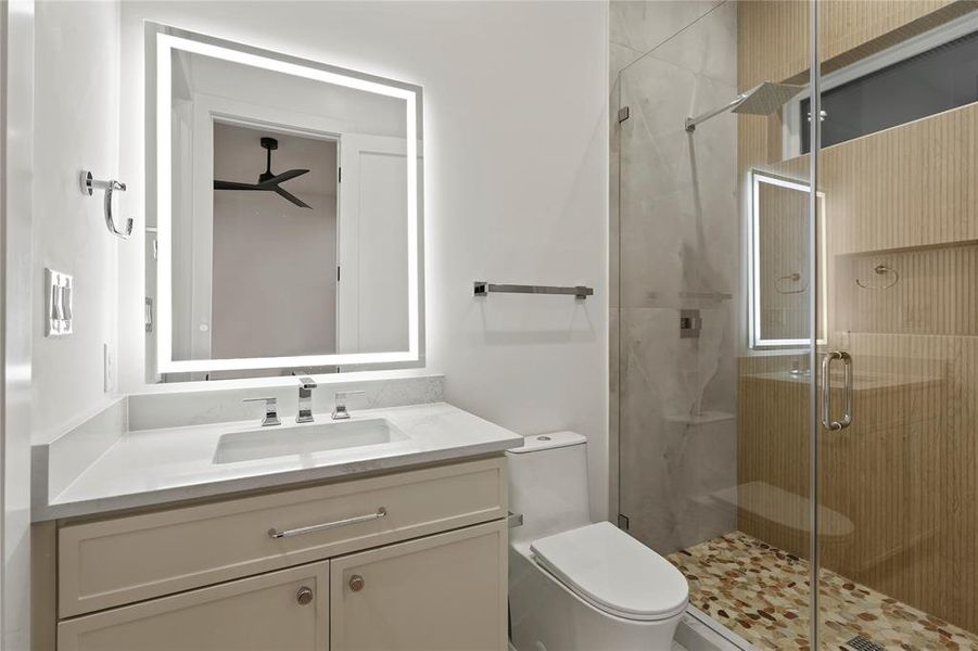 Bathroom with a shower stall, vanity, and ceiling fan