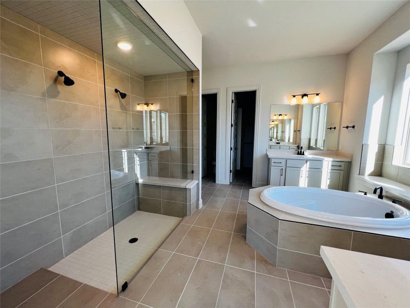 Bathroom featuring vanity, a walk in shower, a garden tub, light tile patterned floors, and recessed lighting