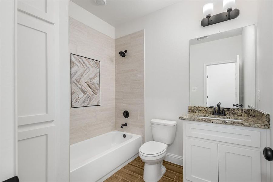 Secondary bath with gorgeous detailed tile and linen cabinets.