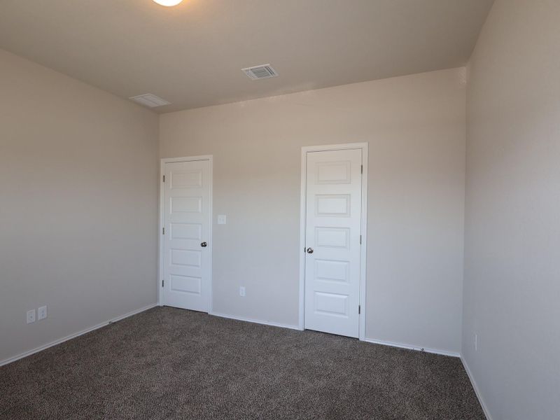 Empty room with dark colored carpet and baseboards