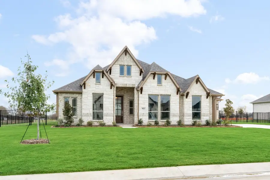 Single-story home with light stone exterior, steep roofline, large windows, and manicured front lawn Single-story home with light stone exterior, steep roofline, large windows, and manicured front lawn