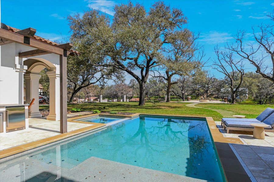 Relaxing pool / spa featuring a patio and a lawn