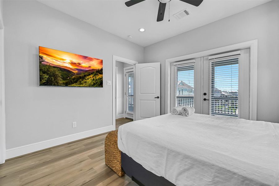 Another view of primary bedroom two upstairs with a view of the doors leading outside to the expansive deck with gulf views!