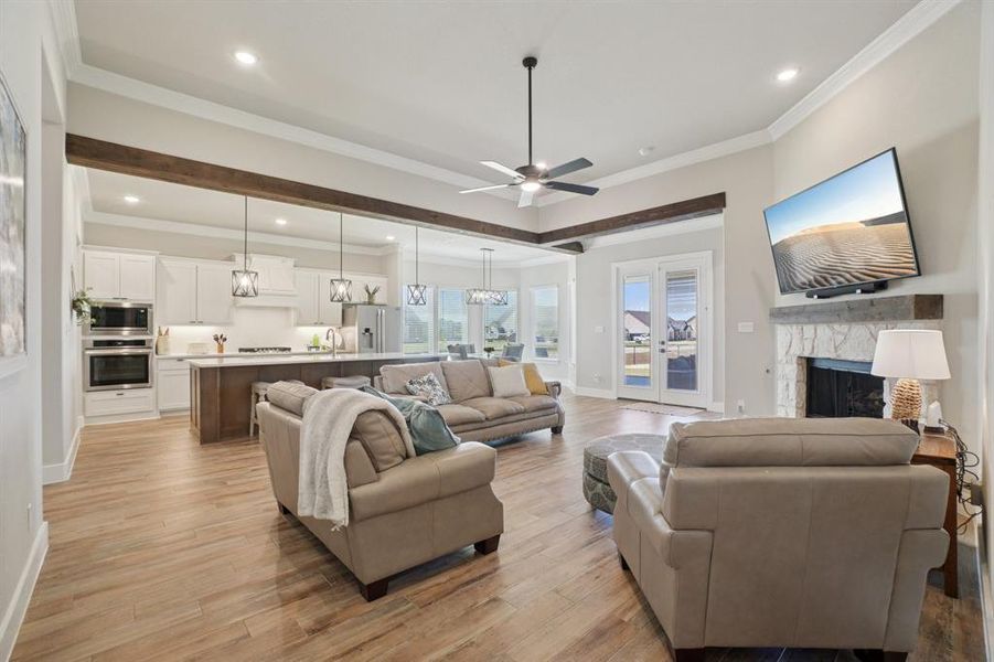 Living area featuring light wood-look ceramic tile floors, ornamental molding, a fireplace, recessed lighting, and ceiling fan