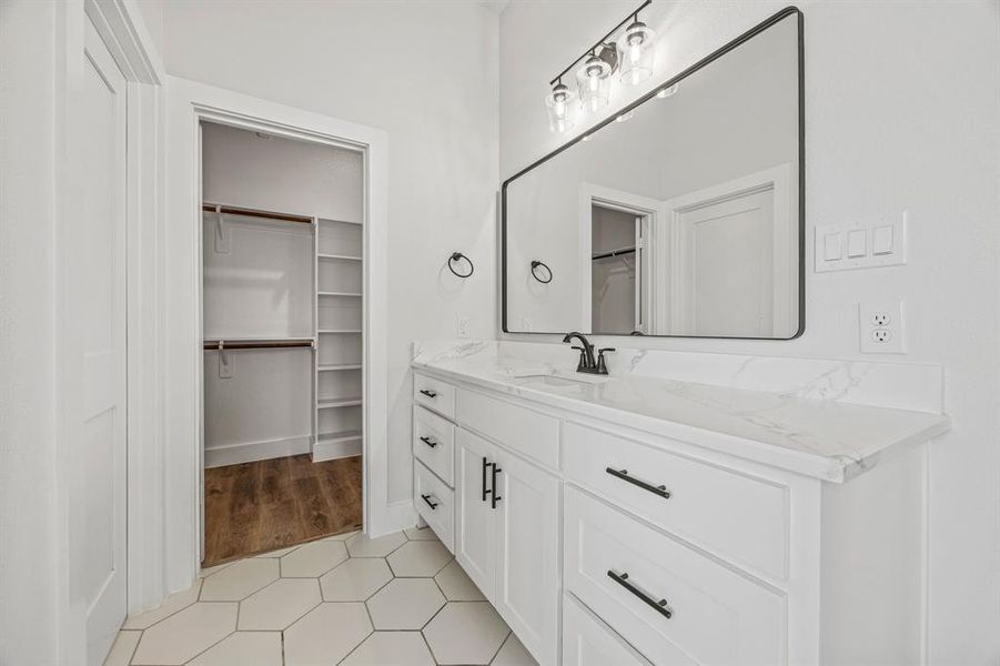 Full bathroom featuring vanity and a walk in closet Full bathroom featuring vanity and a walk in closet