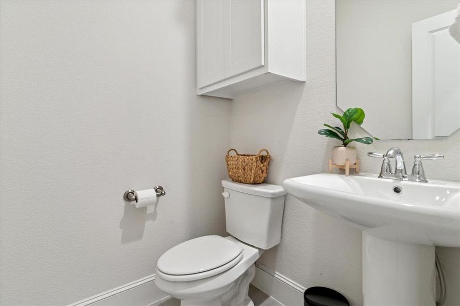 Half bathroom featuring a textured wall Half bathroom featuring a textured wall