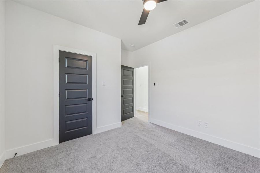 Carpeted spare room featuring ceiling fan