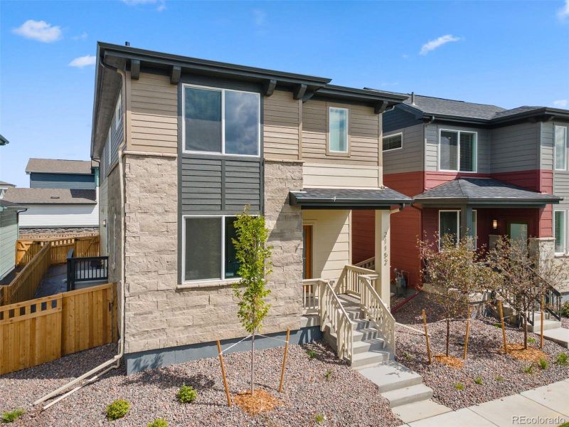 Front exterior of a new home in Woodrose at Painted Prairie, Aurora, CO, highlighting curb appeal (Image 22).