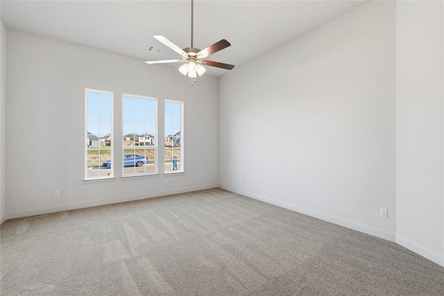 Spare room featuring light carpet and a ceiling fan