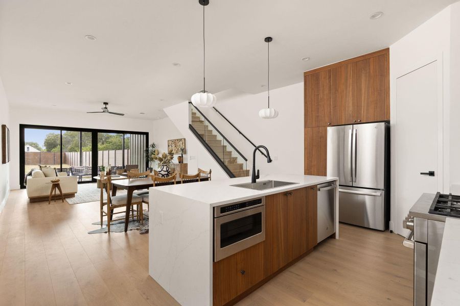 An open-concept living space integrates a modern kitchen and dining area with access to outdoor living.