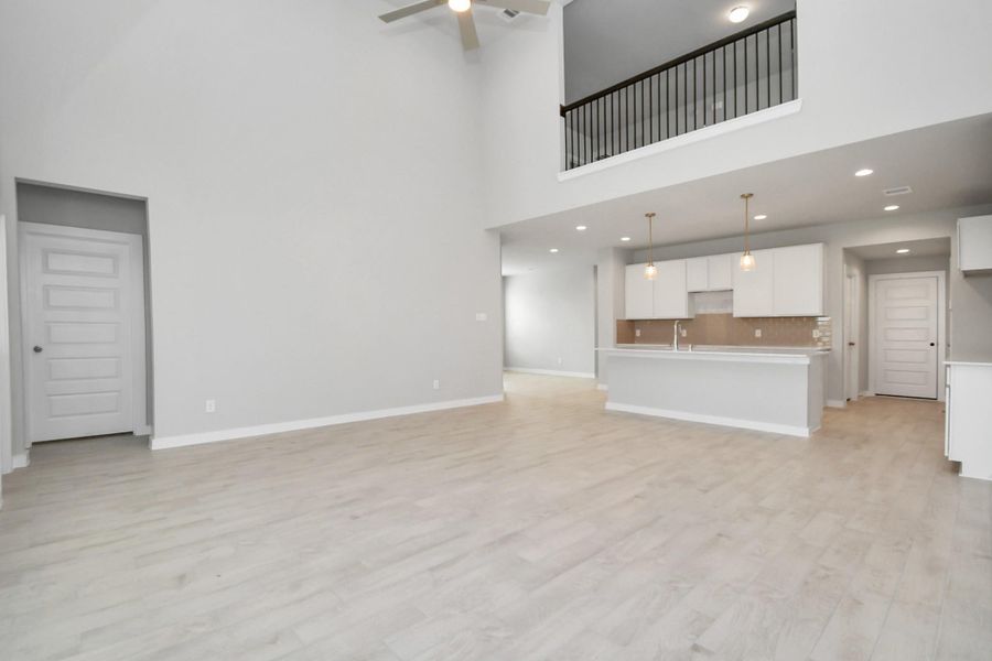 Bring the family and guests together in the welcoming family room! Enjoy the expansive space adorned with high ceilings, recessed lighting, a stylish ceiling fan, custom paint, exquisite flooring, and generously sized windows that fill the room with an abundance of natural light, creating a warm and inviting atmosphere for everyone to enjoy. Sample photo of completed home with similar floor plan. Actual colors and selections may vary. Bring the family and guests together in the welcoming family room! Enjoy the expansive space adorned with high ceilings, recessed lighting, a stylish ceiling fan, custom paint, exquisite flooring, and generously sized windows that fill the room with an abundance of natural light, creating a warm and inviting atmosphere for everyone to enjoy. Sample photo of completed home with similar floor plan. Actual colors and selections may vary.