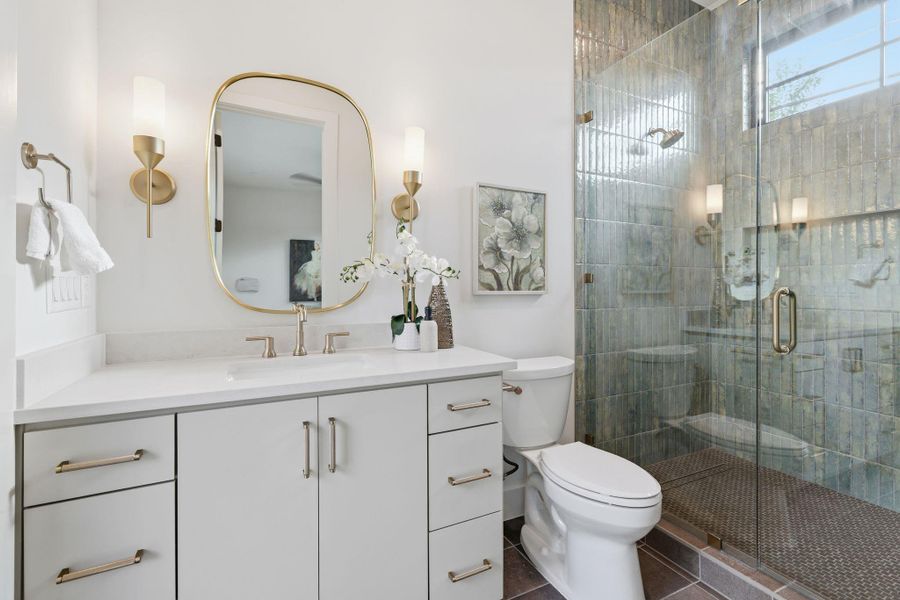 Full bathroom featuring vanity, dark tile patterned floors, and a walk-in shower
