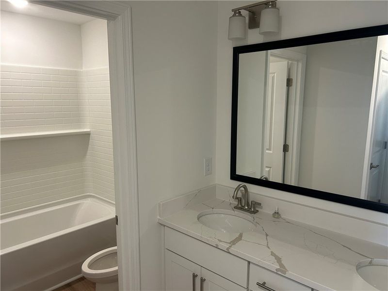 Double vanity with sleek countertops offers abunda