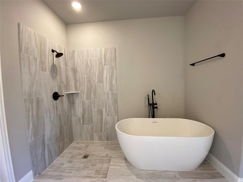 Master bath offers elegant free-standing tub and separate shower with bropped pan & frameless glass surround (not installed yet)