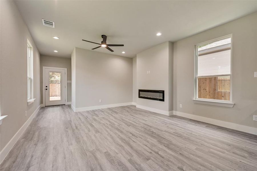 Unfurnished living room featuring recessed lighting, ceiling fan, and fireplace Unfurnished living room featuring recessed lighting, ceiling fan, and fireplace