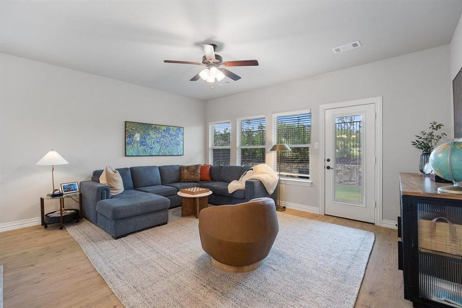Living area with light wood-type flooring and ceiling fan