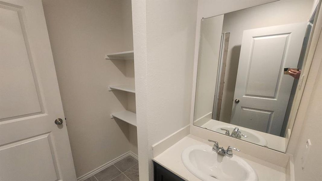 Vanity featuring a rectangular mirror, a white countertop, and a built-in sink with a chrome faucet