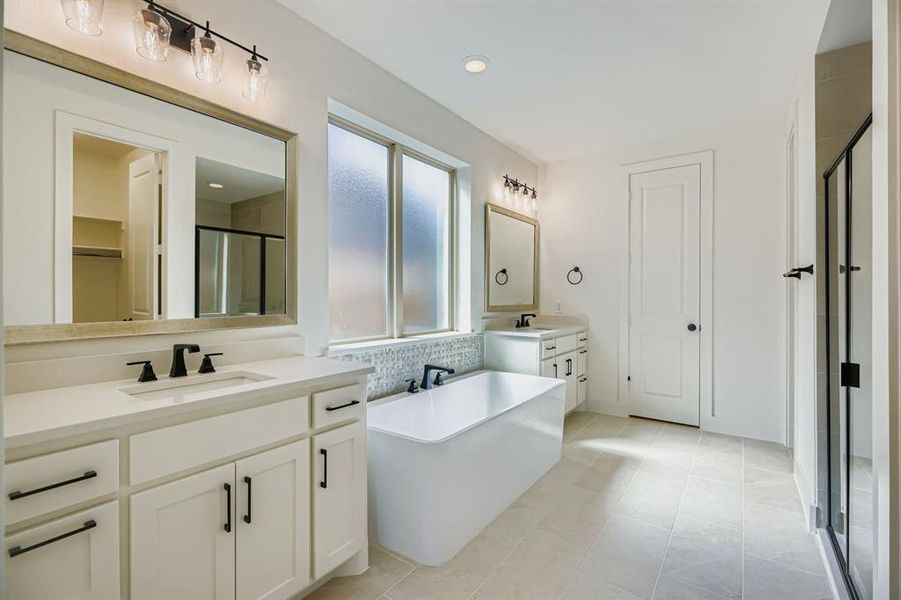 Bathroom featuring a freestanding tub, a shower stall, decorative backsplash, two vanities, and recessed lighting Bathroom featuring a freestanding tub, a shower stall, decorative backsplash, two vanities, and recessed lighting