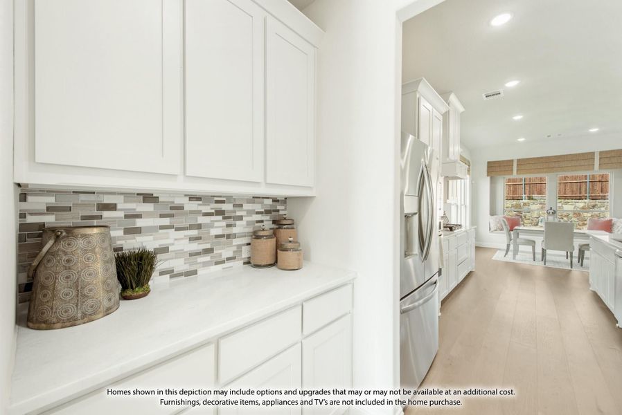 Kitchen with white cabinets, gray tile backsplash, and stainless steel refrigerator open to dining area Kitchen with white cabinets, gray tile backsplash, and stainless steel refrigerator open to dining area