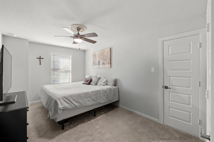 Bedroom featuring light colored carpet and ceiling fan Bedroom featuring light colored carpet and ceiling fan