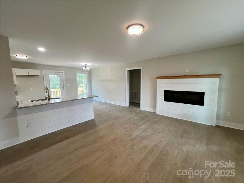 Bright living room featuring a sleek electronic fireplace with shiplap.