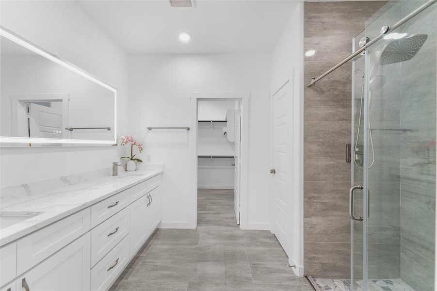 Contemporary bathroom featuring a spacious vanity with white cabinetry and a light-toned countertop