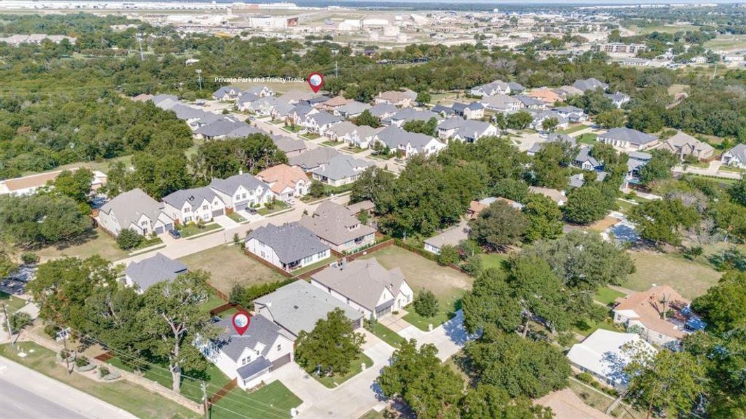 Aerial view of property and surrounding area with nearby suburban area and a tree filled landscape