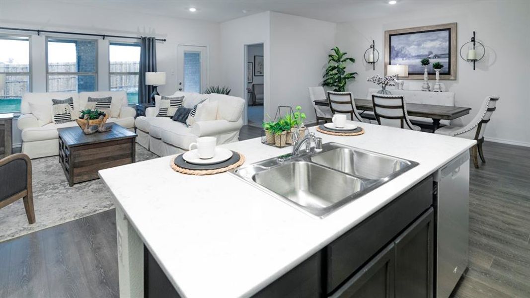 Kitchen featuring a kitchen island with sink, light countertops, open floor plan, dishwasher, and recessed lighting