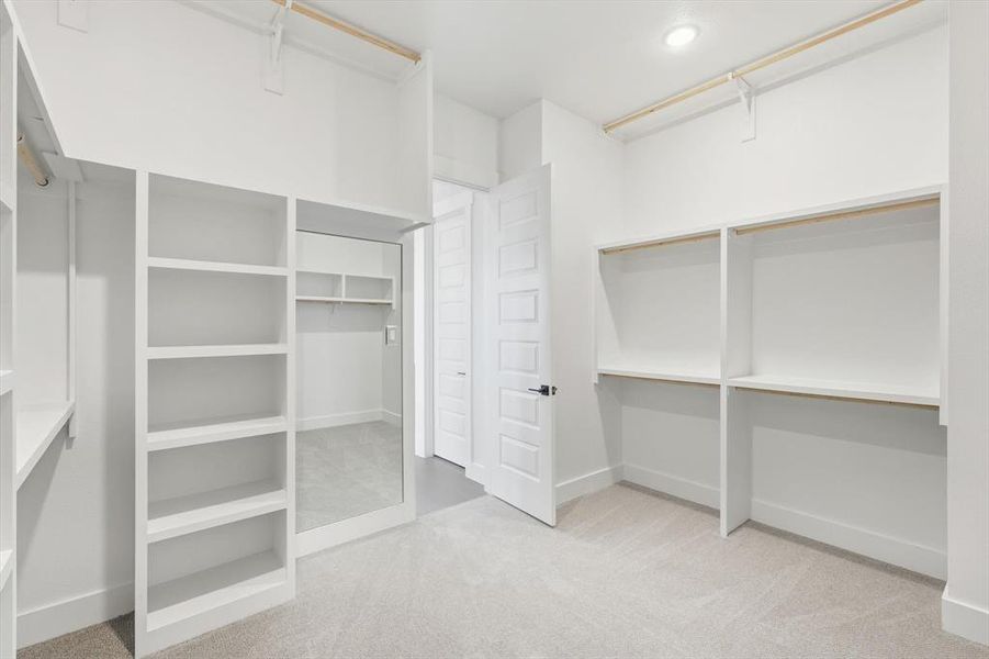 Custom walk-in closet with access to laundry room