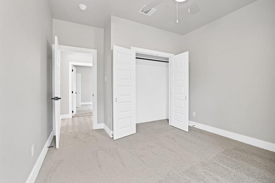 Unfurnished bedroom with light carpet, a closet, and ceiling fan