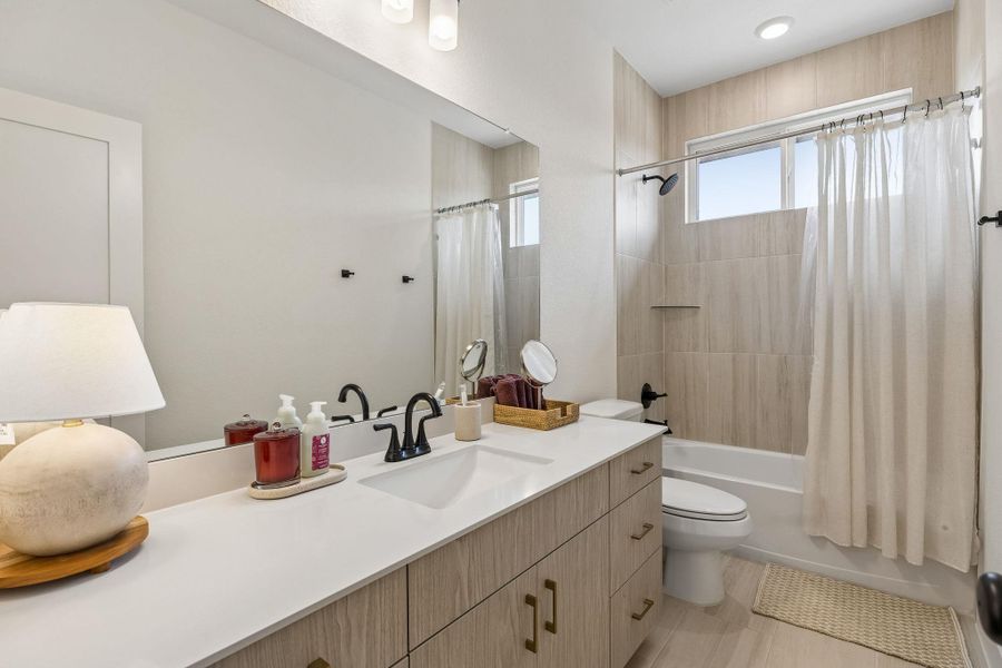Clean lines and warm wood accents define this modern full bathroom setup.