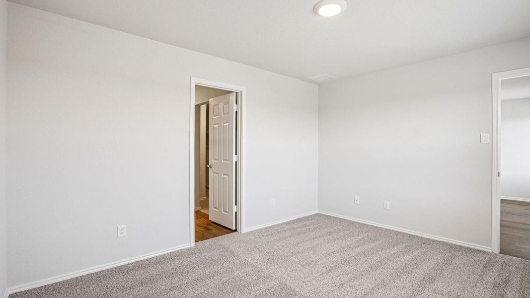 Spacious room featuring light gray wall paint, gray patterned carpet, a recessed ceiling light, and white trim Spacious room featuring light gray wall paint, gray patterned carpet, a recessed ceiling light, and white trim